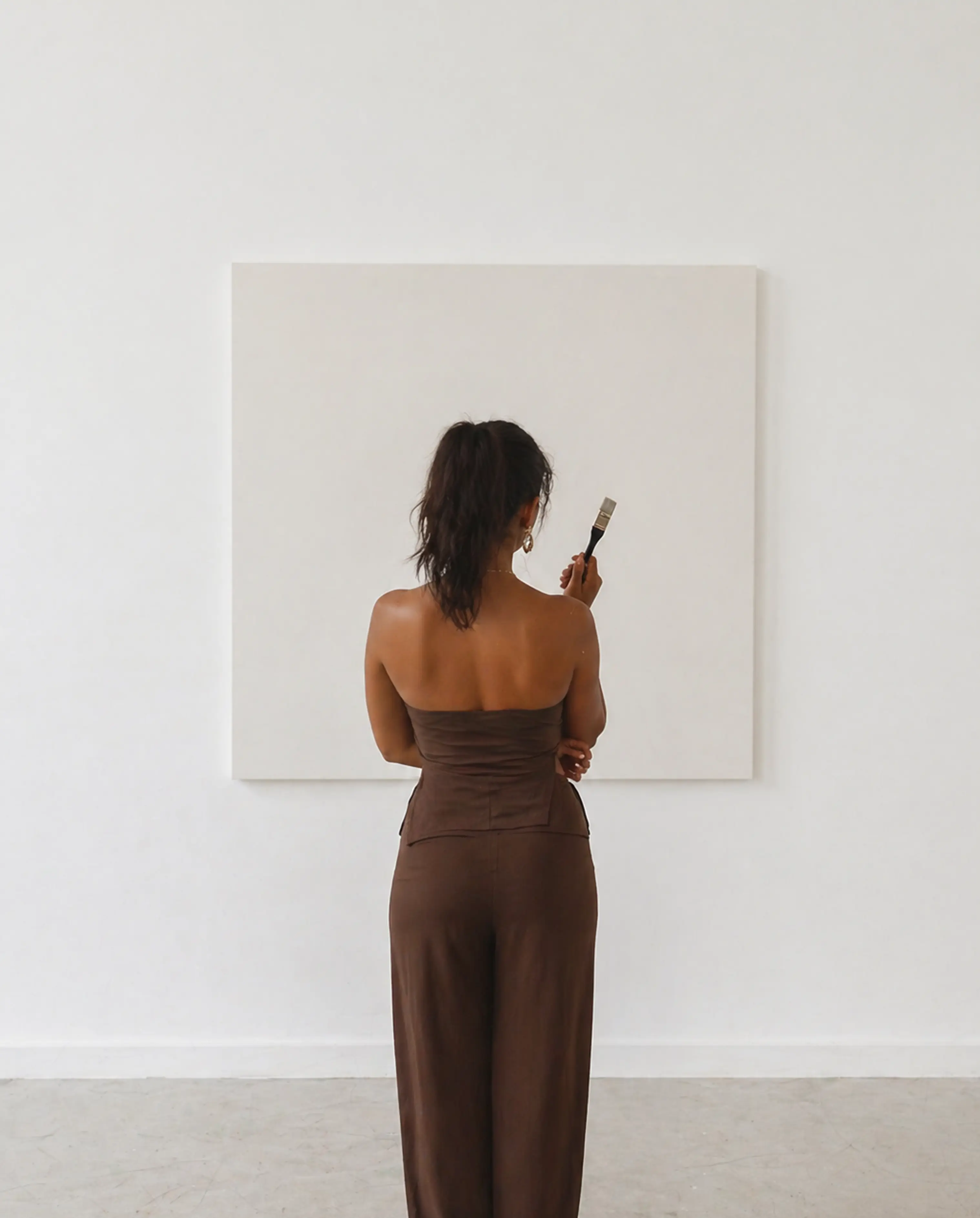 Ashley Vong standing infront of an canvas thinking